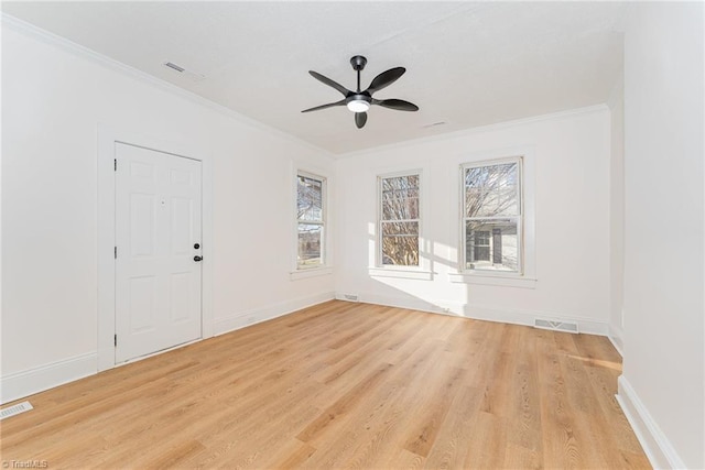 empty room with visible vents, baseboards, a ceiling fan, crown molding, and light wood-type flooring