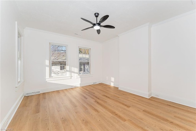 spare room featuring ornamental molding, visible vents, and light wood-style floors