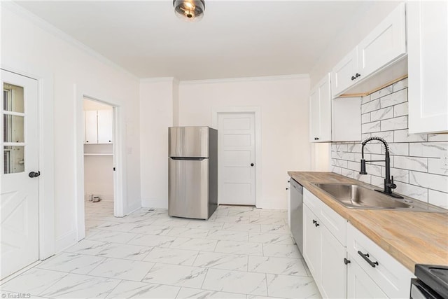 kitchen with white cabinets, appliances with stainless steel finishes, marble finish floor, crown molding, and a sink