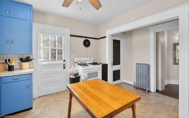 kitchen with decorative backsplash, radiator heating unit, white gas stove, and blue cabinets