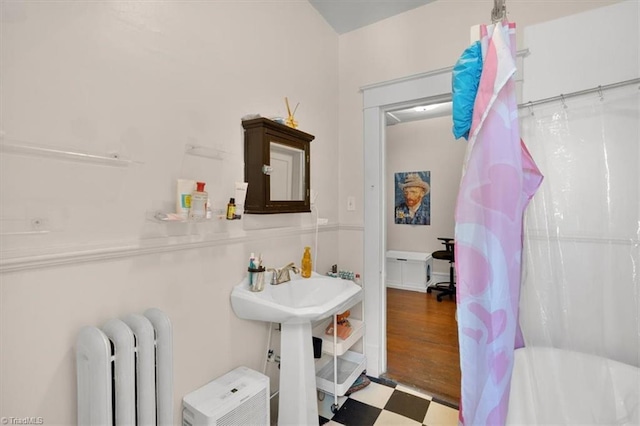 bathroom featuring walk in shower, radiator heating unit, and hardwood / wood-style floors