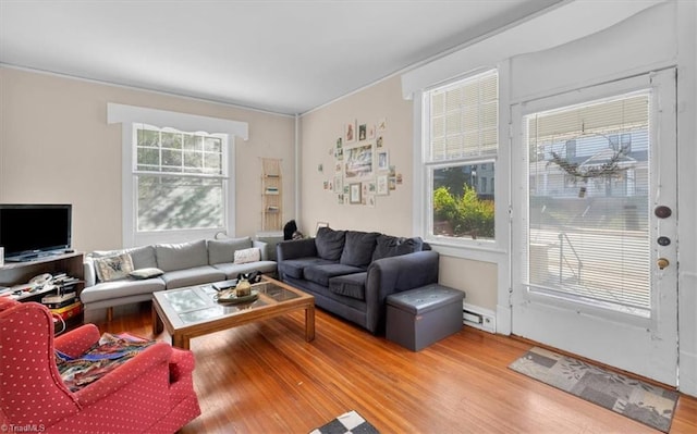 living room with a baseboard heating unit, hardwood / wood-style flooring, and plenty of natural light