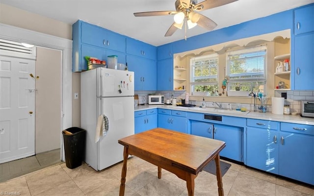 kitchen with sink, decorative backsplash, blue cabinets, and white appliances