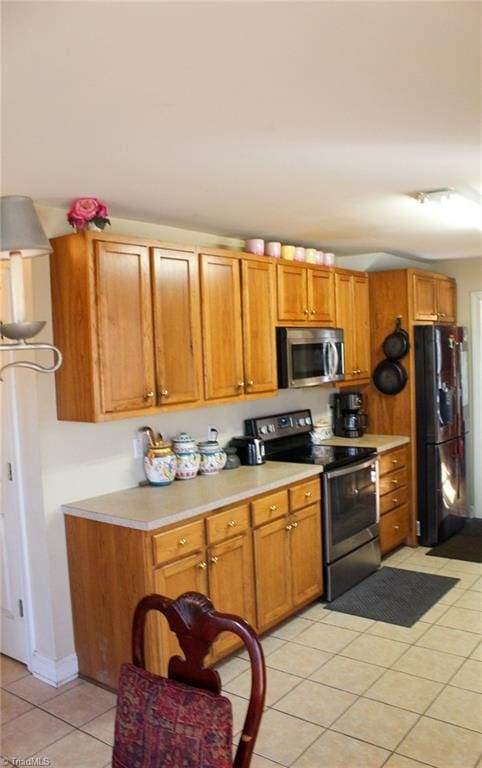 kitchen with stainless steel appliances and light tile patterned floors