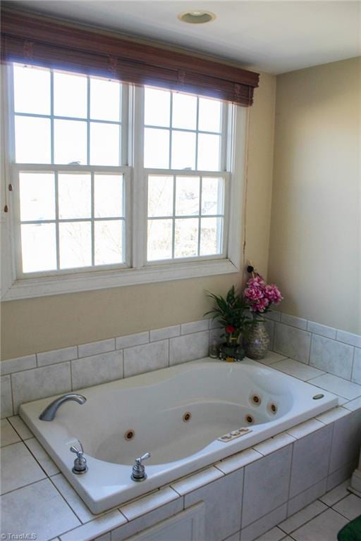 bathroom with tile patterned flooring and tiled bath