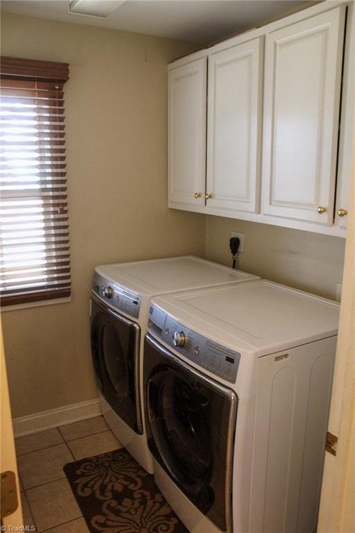 washroom with cabinets, washer and dryer, and light tile patterned floors