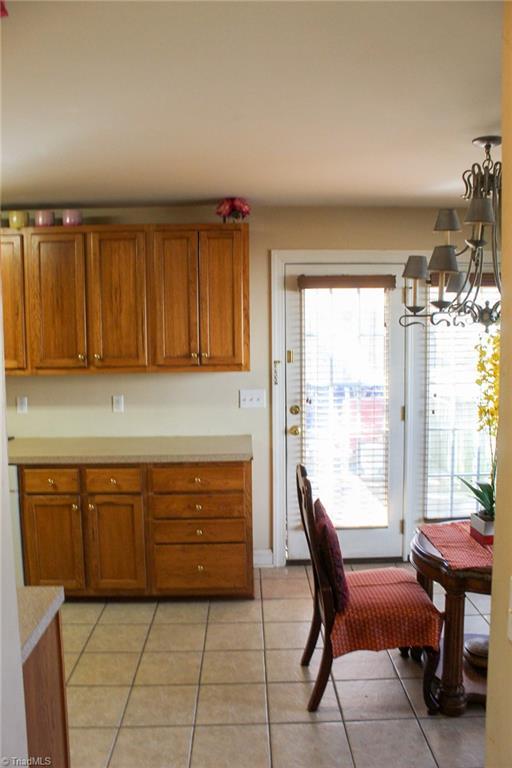 kitchen with light tile patterned flooring and a notable chandelier