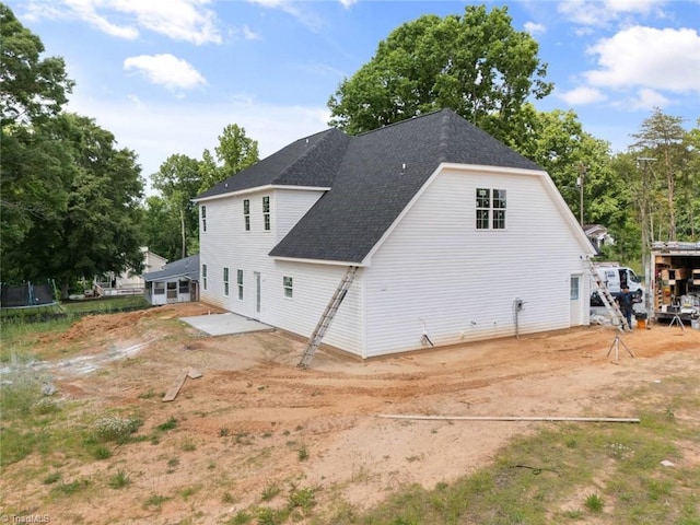 594 Cedar Dr, Winston-Salem, NC 27107 - rear view of property featuring a trampoline, a patio, and a shingled roof