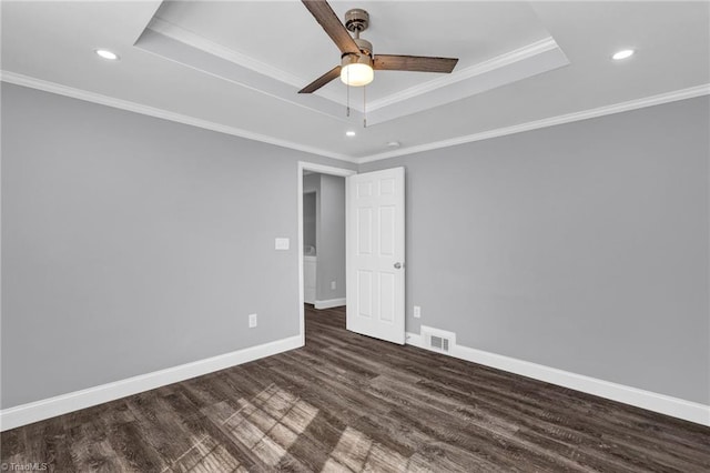 spare room with crown molding, a raised ceiling, and dark hardwood / wood-style floors