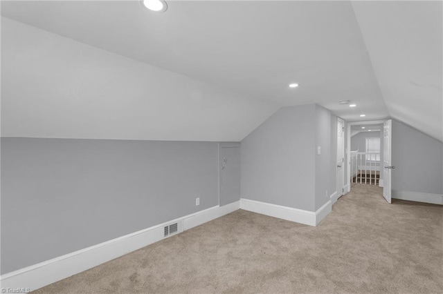 bonus room featuring vaulted ceiling and light colored carpet