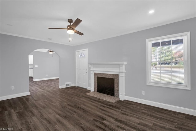 unfurnished living room featuring dark wood-type flooring, crown molding, and ceiling fan