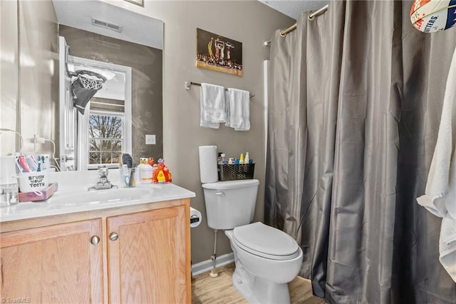 bathroom featuring vanity, wood-type flooring, and toilet