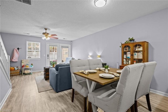 dining space featuring ceiling fan, a textured ceiling, and light hardwood / wood-style flooring