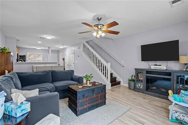 living room featuring ceiling fan and light wood-type flooring