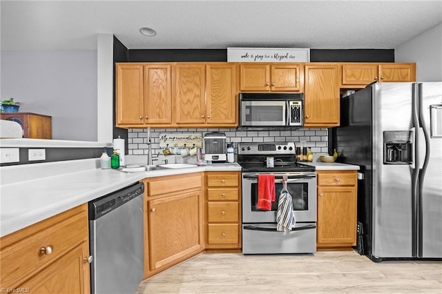 kitchen featuring tasteful backsplash, appliances with stainless steel finishes, and light hardwood / wood-style floors