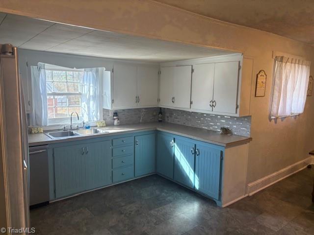 kitchen with appliances with stainless steel finishes, tasteful backsplash, white cabinetry, and sink