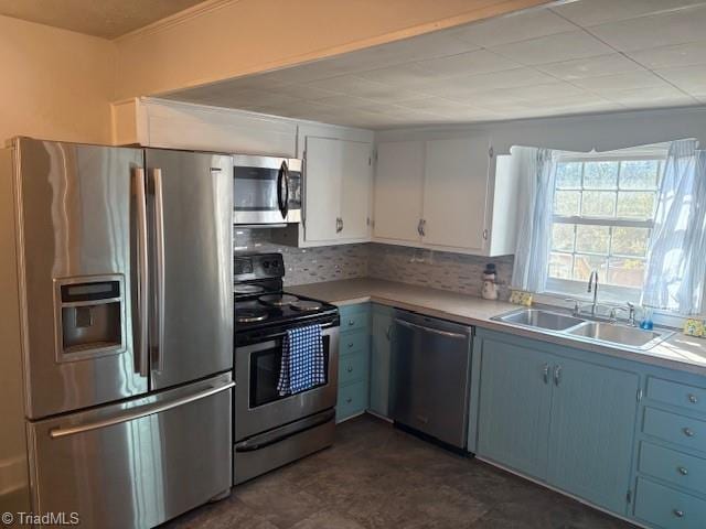 kitchen with backsplash, white cabinets, blue cabinets, sink, and stainless steel appliances