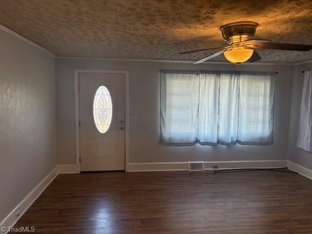 entryway with ceiling fan, dark wood-type flooring, and ornamental molding