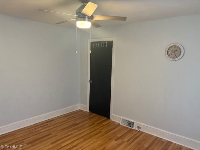 empty room with ceiling fan and hardwood / wood-style flooring