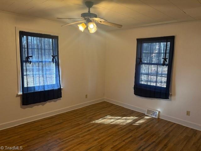 unfurnished room with ceiling fan and dark wood-type flooring