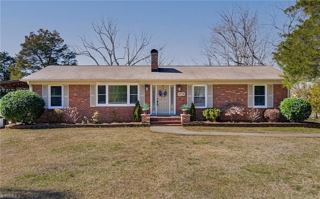 ranch-style home with a front yard, brick siding, and a chimney