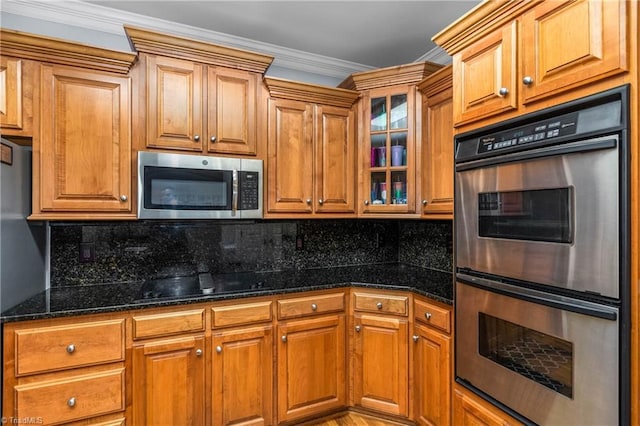 8300 Trottington Rd, Stokesdale, NC 27357 - kitchen featuring stainless steel appliances, brown cabinets, dark stone countertops, and crown molding