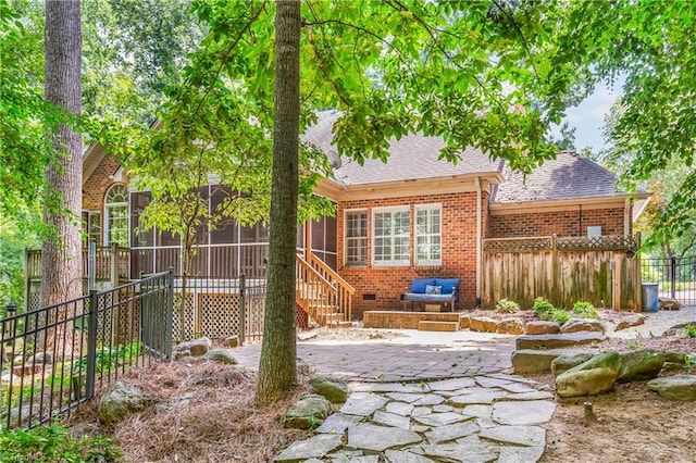 8300 Trottington Rd, Stokesdale, NC 27357 - back of property with a sunroom, roof with shingles, brick siding, and a patio area