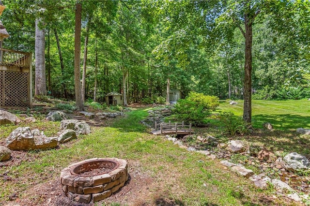 8300 Trottington Rd, Stokesdale, NC 27357 - view of green lawn with an outdoor fire pit, a storage shed, a deck, and a view of trees