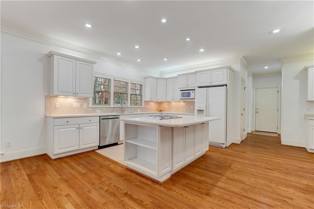 kitchen featuring white appliances, crown molding, white cabinets, light hardwood / wood-style floors, and a kitchen island