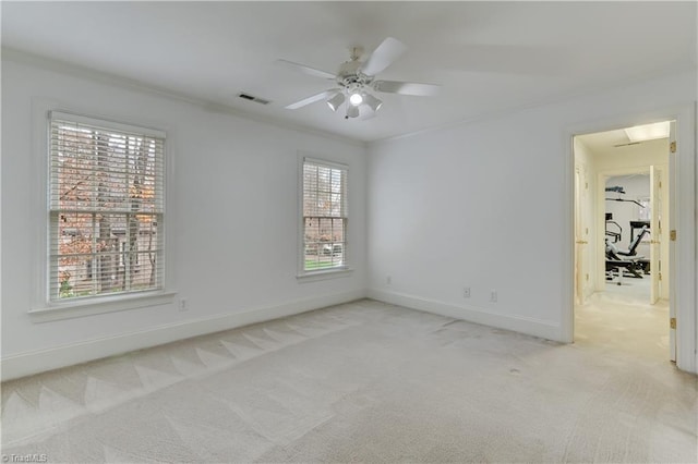 carpeted empty room featuring ceiling fan, plenty of natural light, and ornamental molding