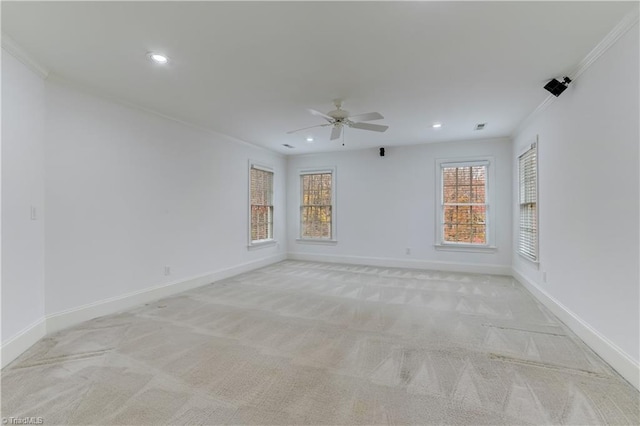 carpeted empty room with ceiling fan and ornamental molding