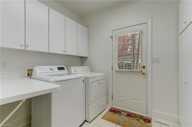 washroom featuring light tile patterned flooring, cabinets, and washing machine and dryer