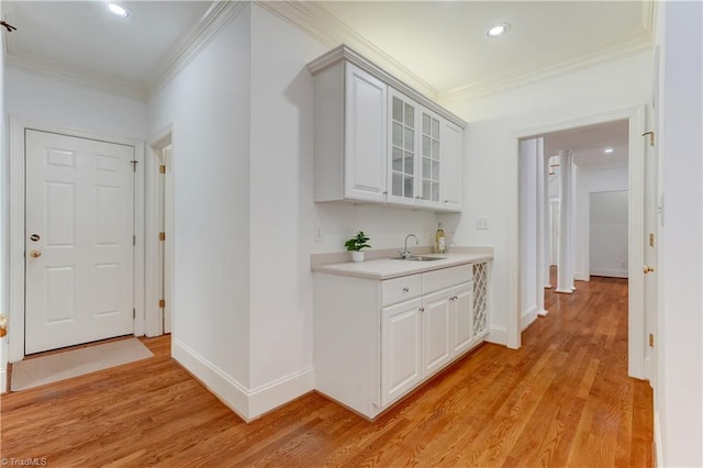 corridor with crown molding, light hardwood / wood-style flooring, and sink