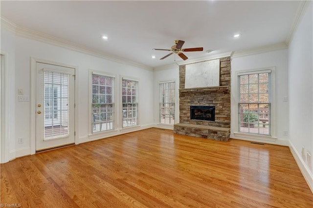 unfurnished living room featuring ceiling fan, light wood-type flooring, a fireplace, and ornamental molding