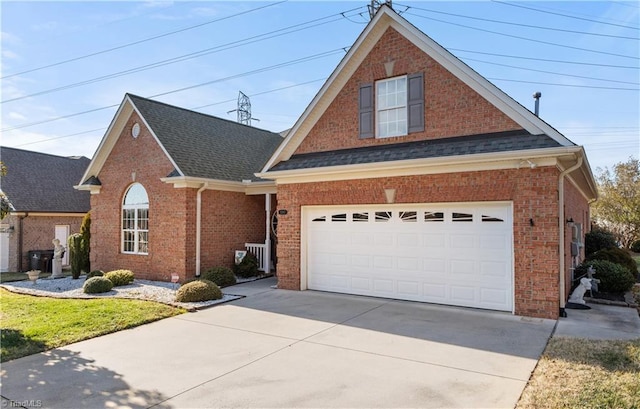 traditional-style home featuring a shingled roof, concrete driveway, and brick siding