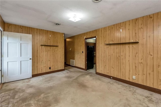 spare room featuring wooden walls