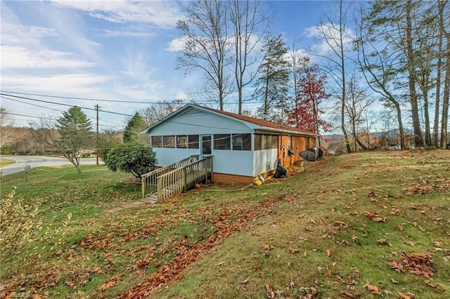 view of front of house featuring a sunroom and a front yard