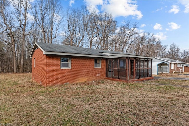 back of property featuring a yard and a sunroom