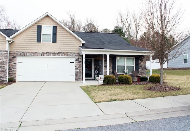 view of front of property featuring a porch, concrete driveway, stone siding, and a front lawn