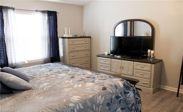 bedroom featuring baseboards and wood finished floors