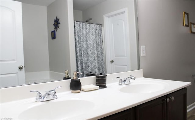 full bathroom with double vanity, a shower with curtain, and a sink