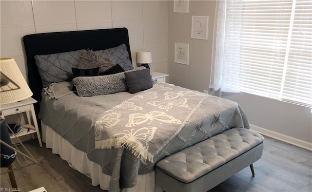 bedroom featuring baseboards and wood finished floors