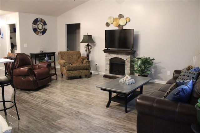 living room featuring a fireplace, lofted ceiling, wood finished floors, and baseboards