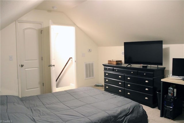 bedroom with visible vents, light colored carpet, and vaulted ceiling