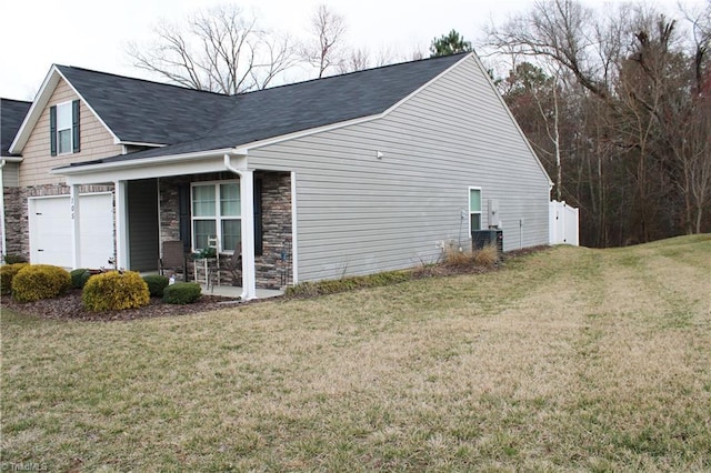 view of home's exterior featuring stone siding, covered porch, and a lawn