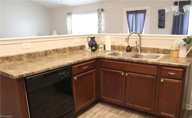 kitchen with light wood finished floors, dishwasher, and a sink