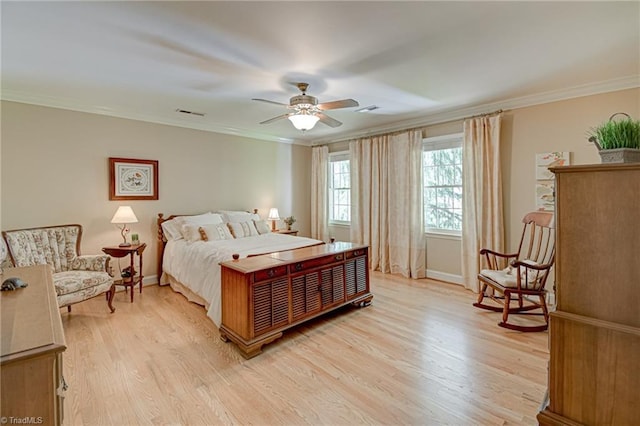 bedroom featuring visible vents, ornamental molding, baseboards, ceiling fan, and light wood-type flooring