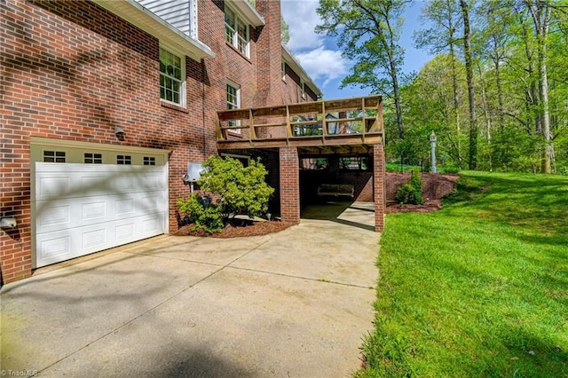 exterior space with a chimney, a yard, a wooden deck, brick siding, and concrete driveway