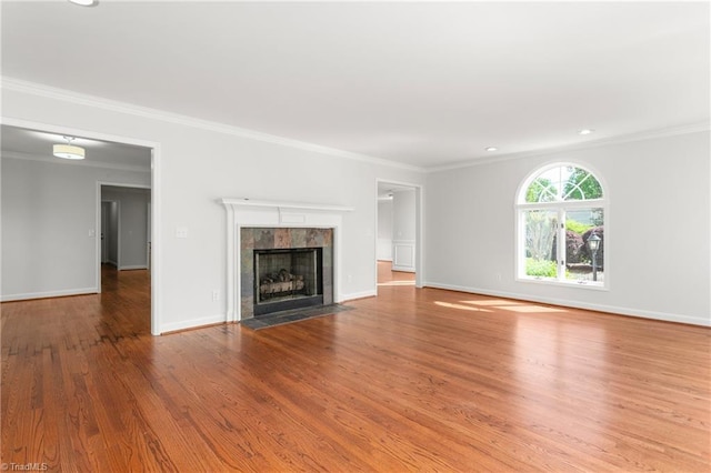 unfurnished living room with ornamental molding, wood finished floors, and baseboards