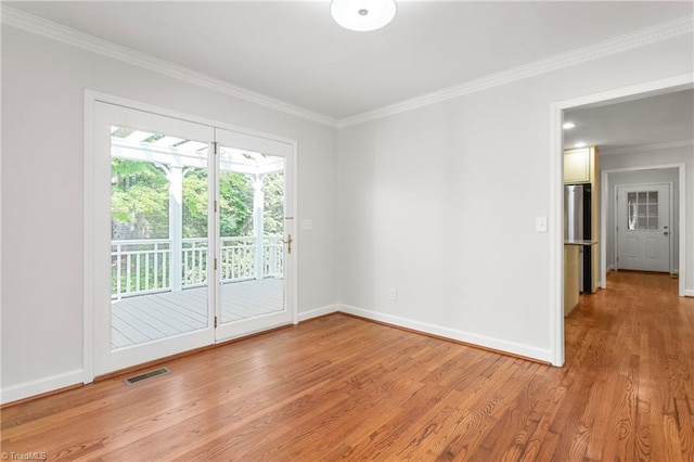 unfurnished room with visible vents, crown molding, light wood-style flooring, and baseboards